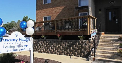 a building with a balcony and a sign in front of it