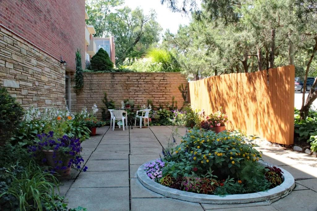 a courtyard with a brick wall and a wooden fence