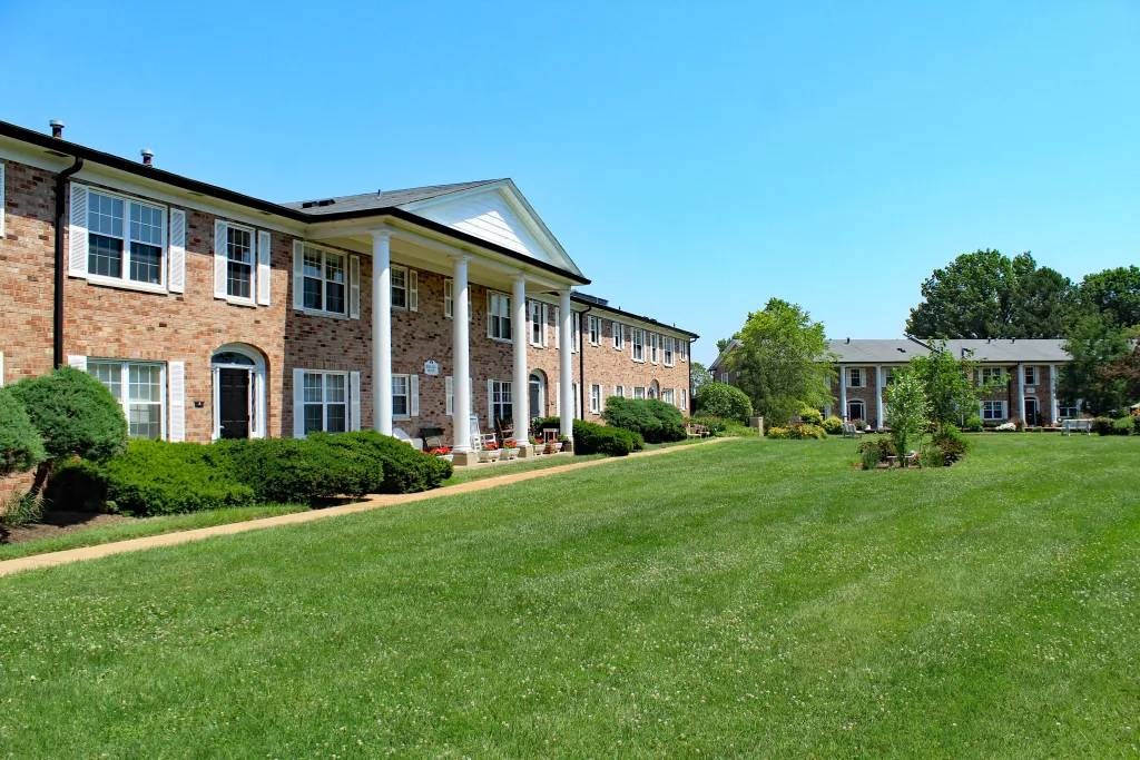 a large green lawn in front of a brick building