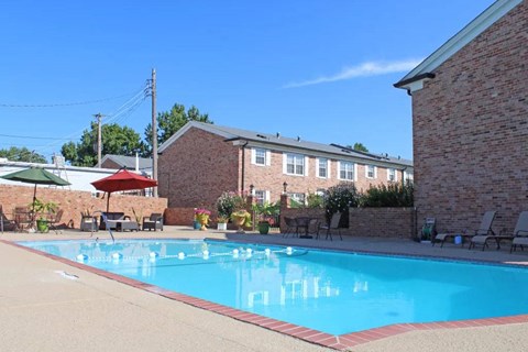 a swimming pool with a brick building in the background