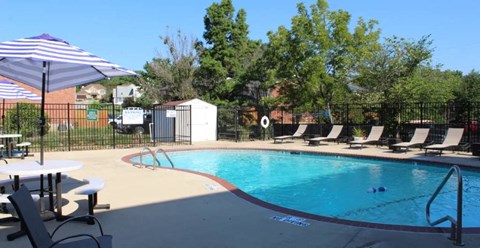 a swimming pool with chaise lounge chairs and an umbrella