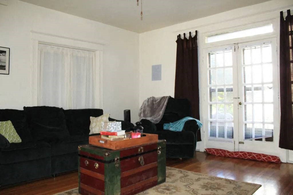 a living room with a couch a chair and a trunk