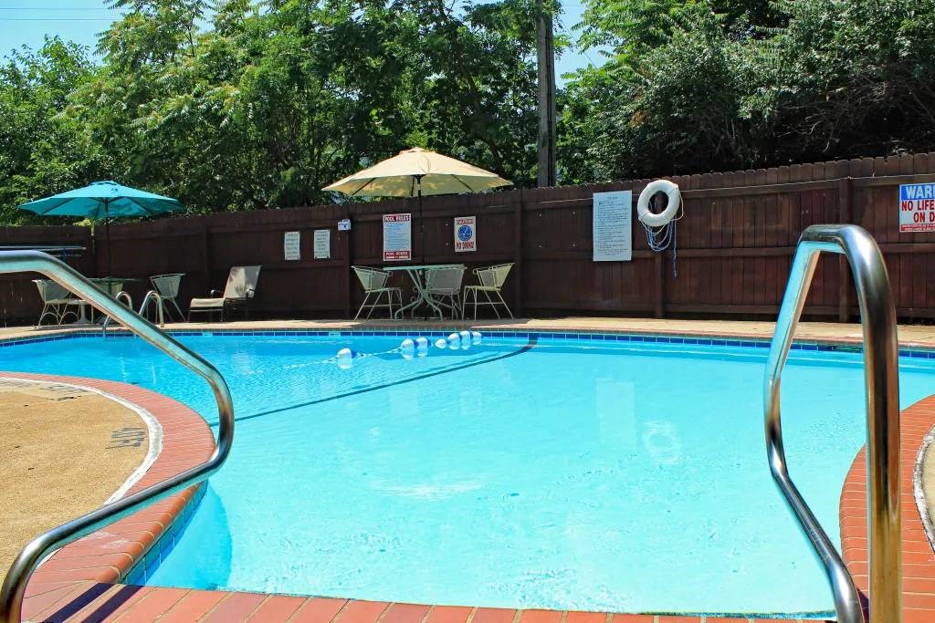 a swimming pool with umbrellas and chairs around it