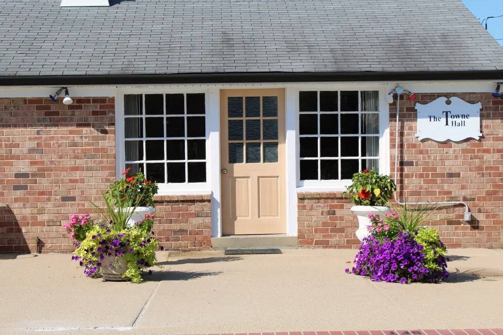 a building with a door and flowers in front of it