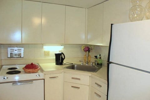 a white kitchen with a sink and a refrigerator