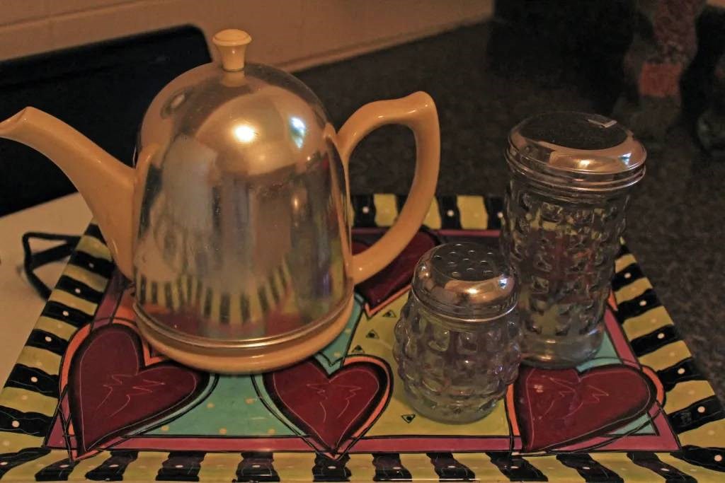 a kettle sitting on top of a table next to a glass jar