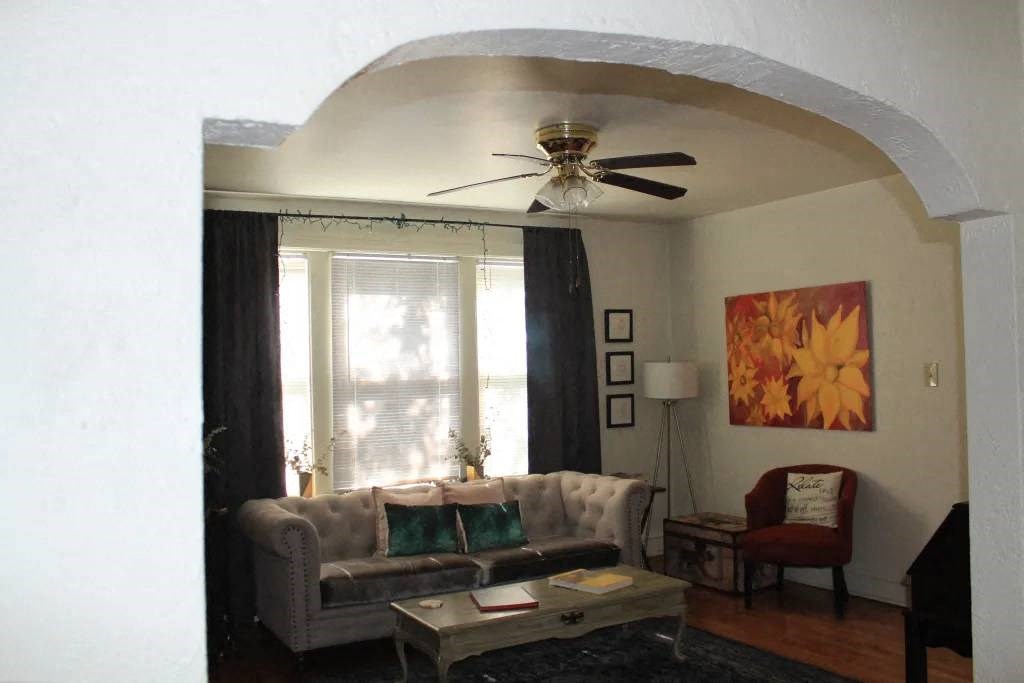 a living room with a couch a coffee table and a ceiling fan