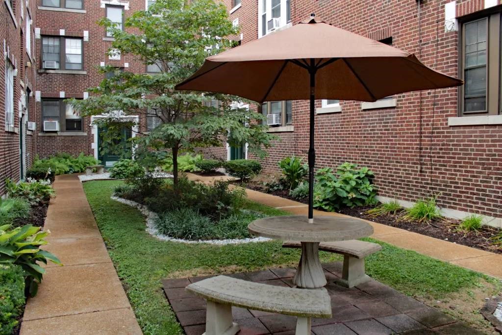 a table with an umbrella sitting next to a brick building