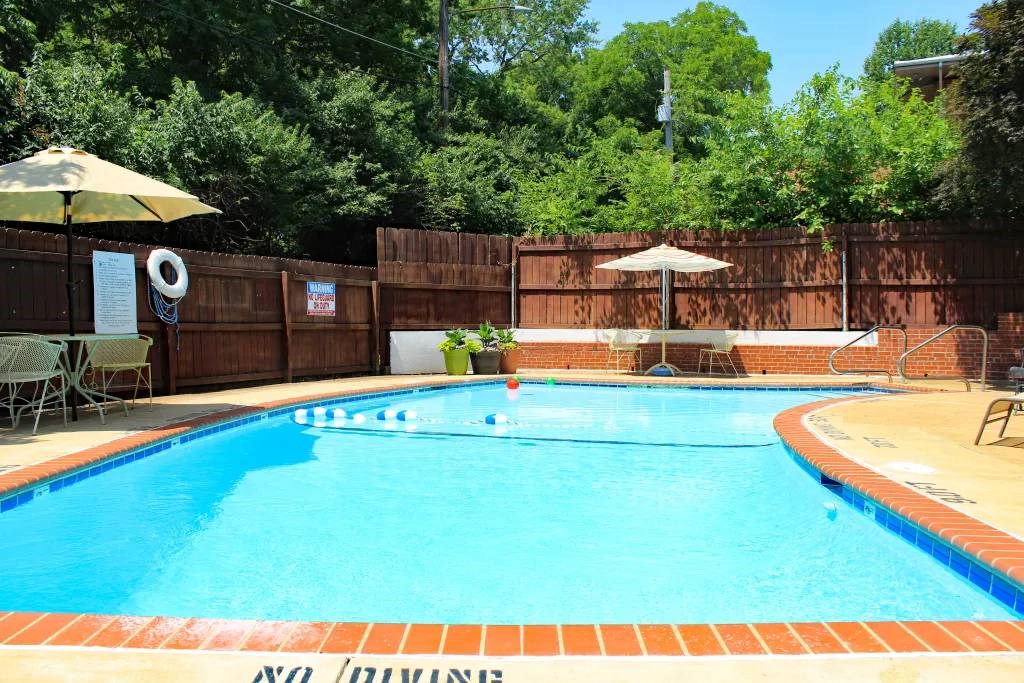 a swimming pool with an umbrella and chairs