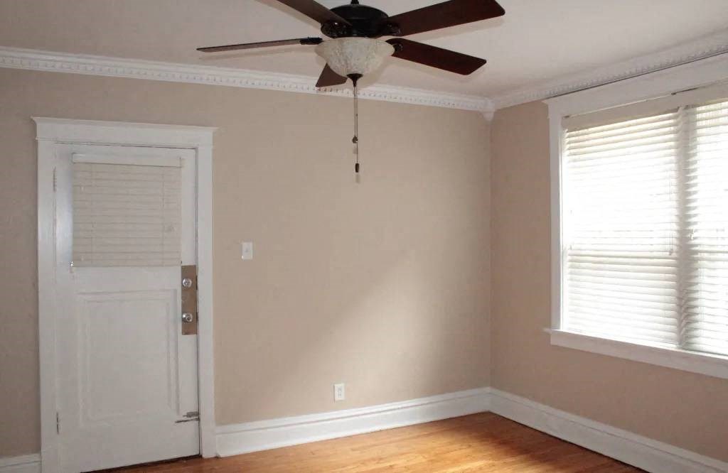 a bedroom with a ceiling fan and a window