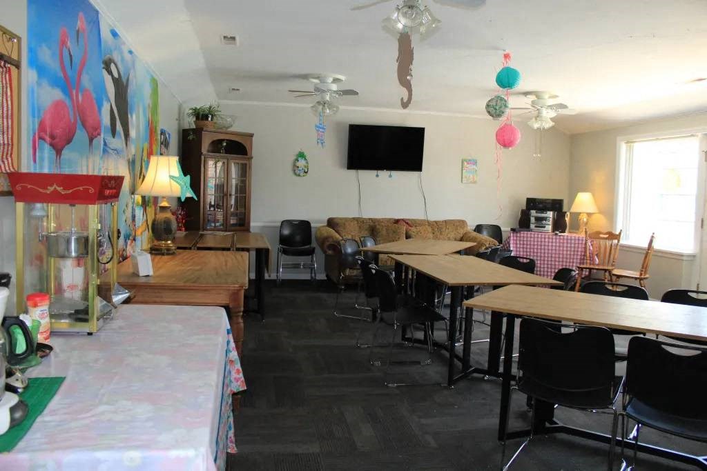 a room with tables and chairs and a television