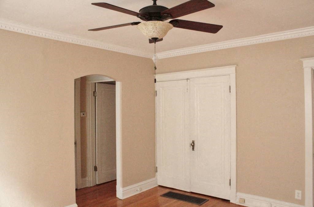 a room with a ceiling fan and two doors