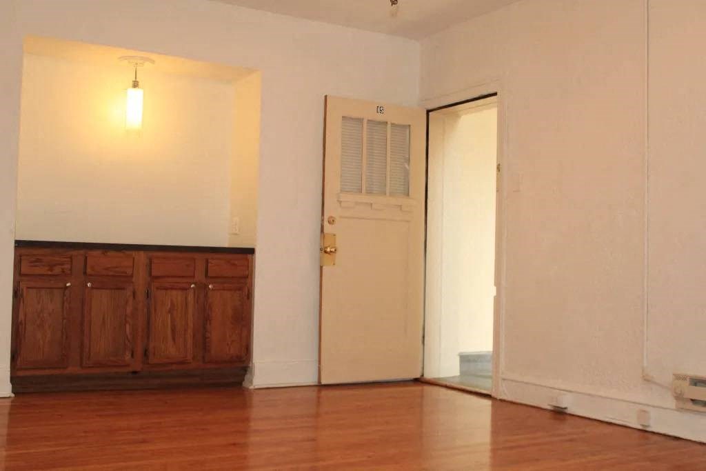 an empty room with a wooden floor and a door