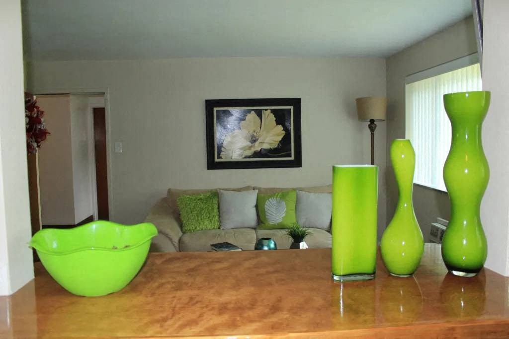 a living room with a wooden table and green vases