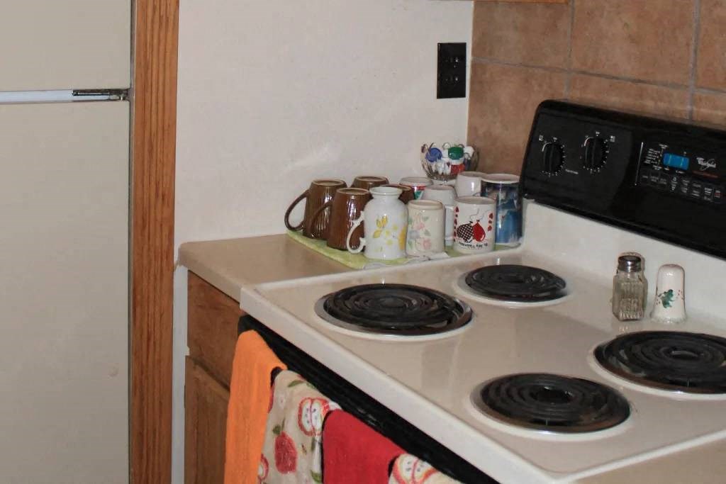 a kitchen with a stove top oven next to a refrigerator