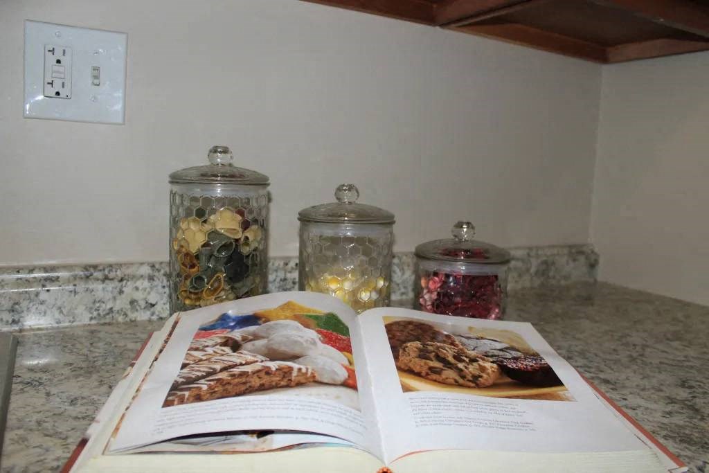 a book laying on a counter next to jars of cookies