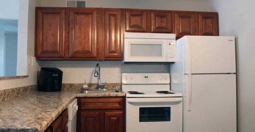 a kitchen with a white stove top oven next to a refrigerator