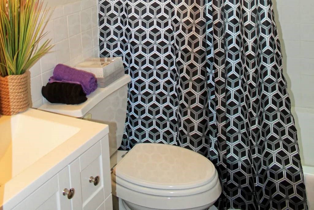 a white toilet sitting next to a bath tub