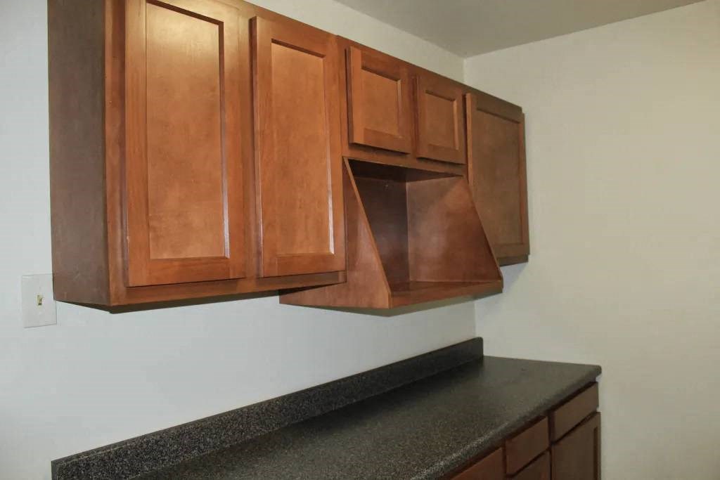 a kitchen with wooden cabinets and a microwave