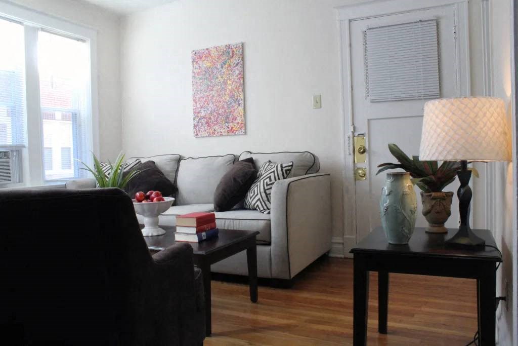 a living room with a couch a table and a lamp