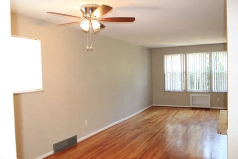 a living room with a ceiling fan and hardwood floors