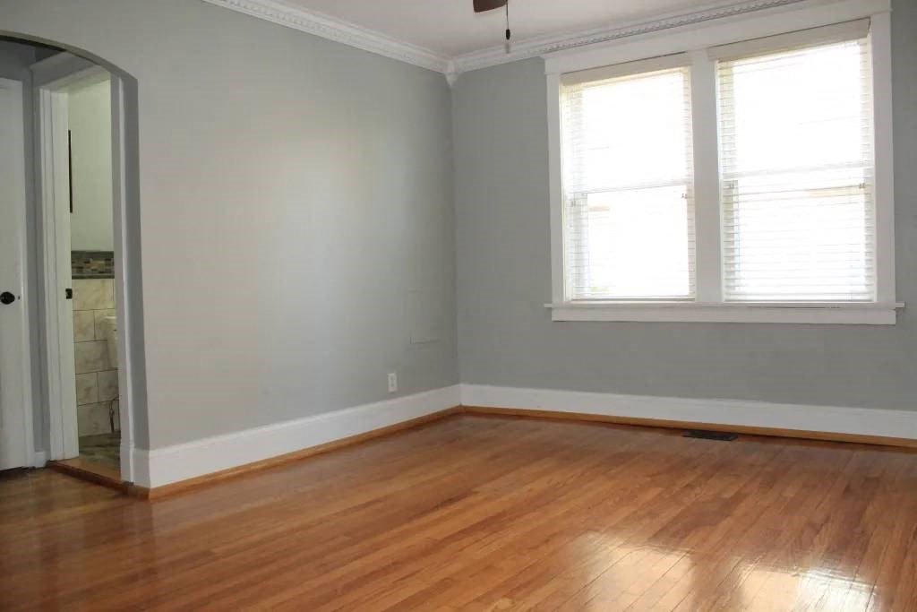 a room with a wooden floor and two windows