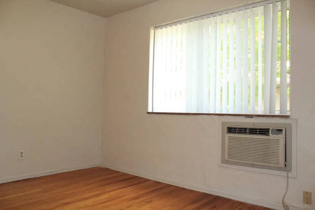 an empty room with a window and an air conditioner