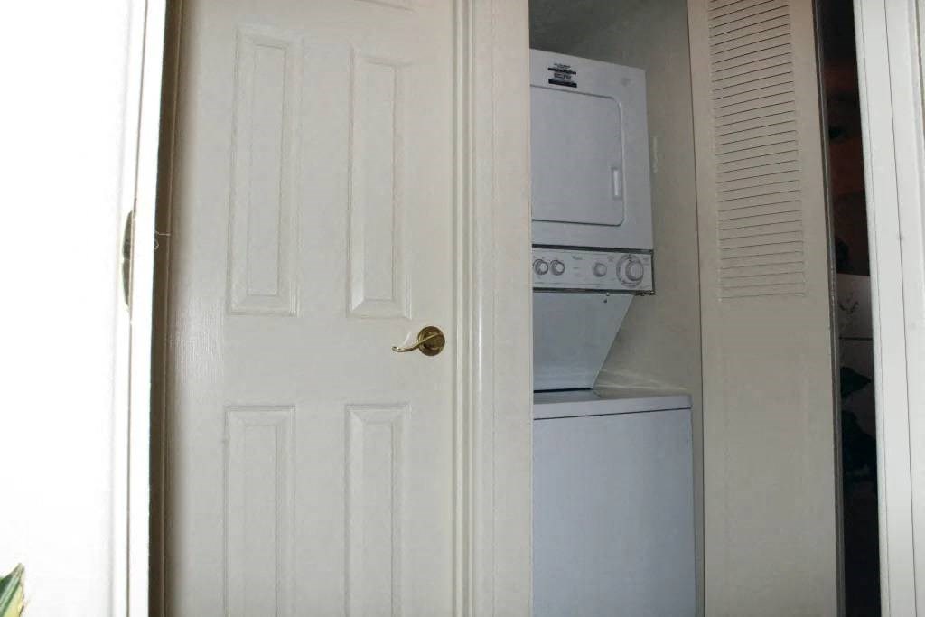 a white door is open to a laundry room with a white washer and dryer