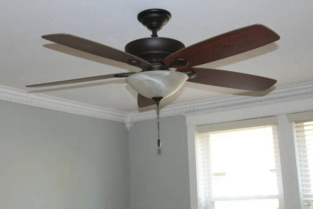 a ceiling fan in a room with a window