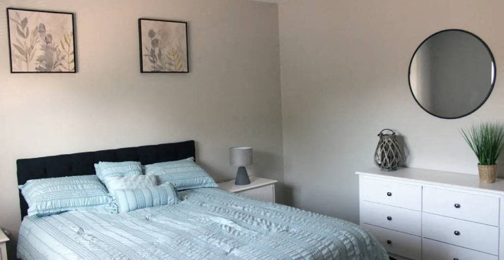 a bedroom with a bed and a dresser in it