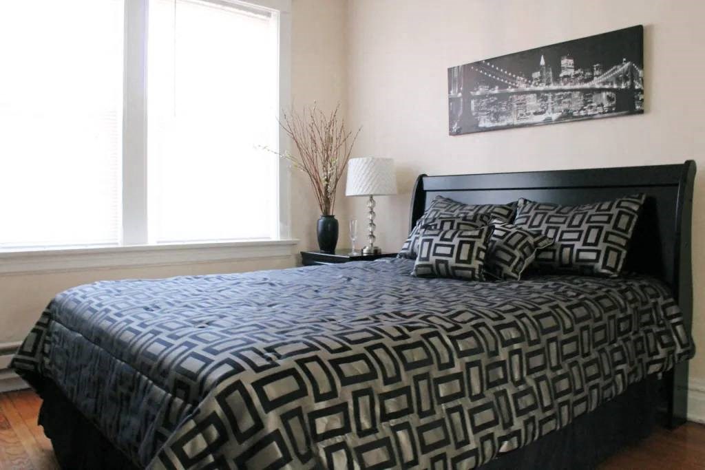 a bedroom with a bed and two windows