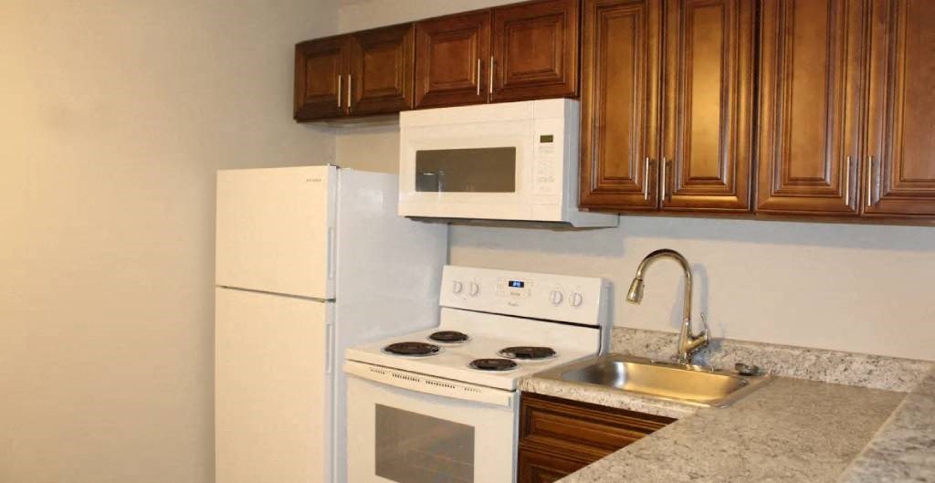 a kitchen with a white refrigerator freezer next to a stove top oven