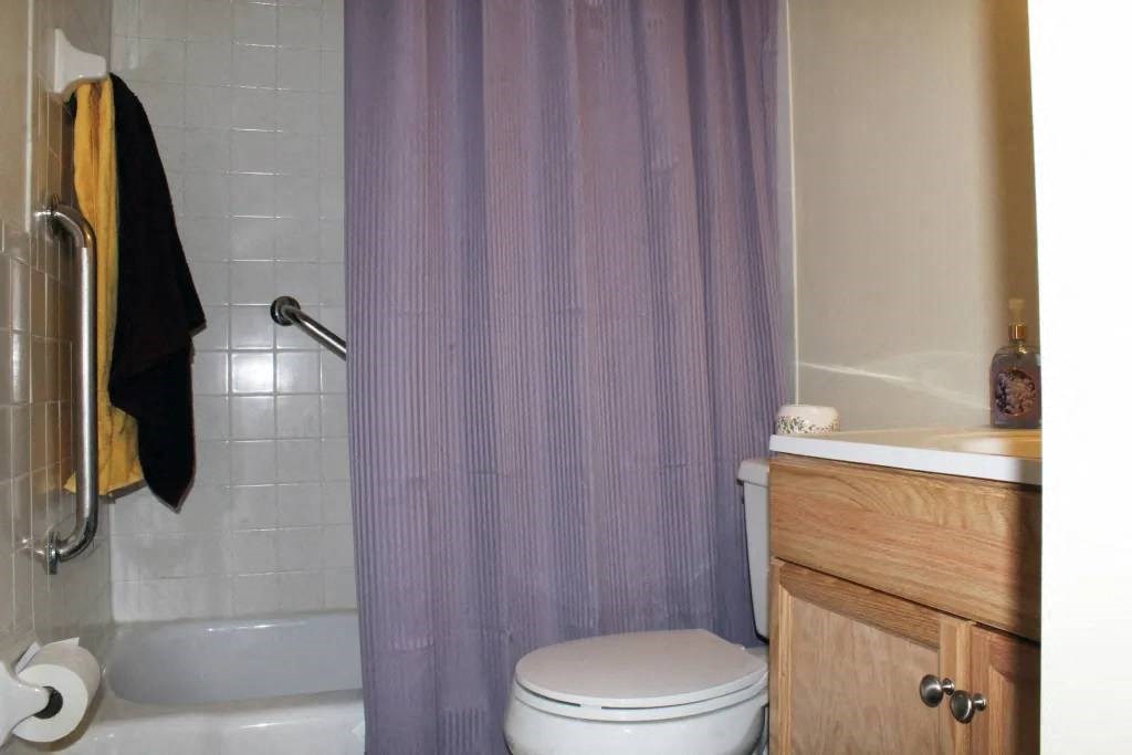 a white toilet sitting next to a bath tub