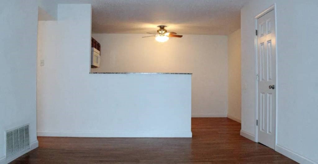 an empty room with a ceiling fan and a door