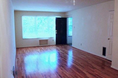 an empty room with a door and two windows