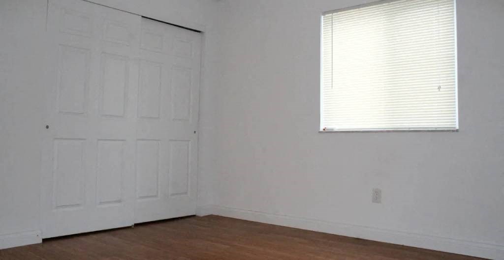 a bedroom with a window and a door