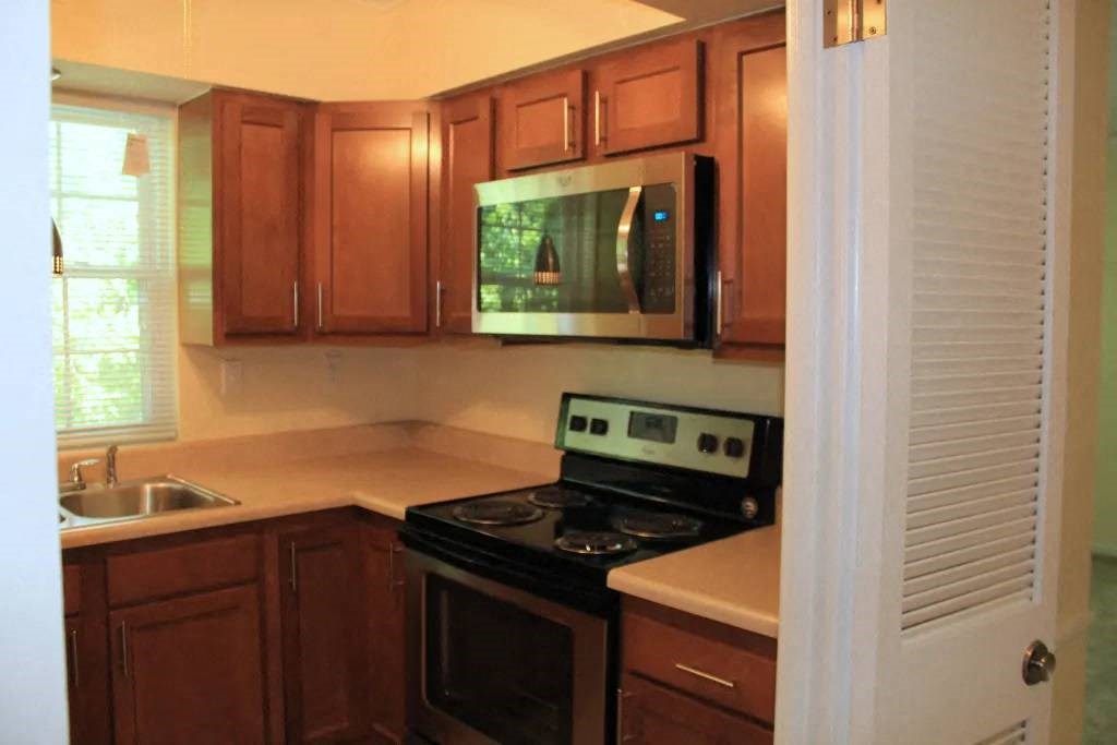 a kitchen with a stove a sink and a microwave
