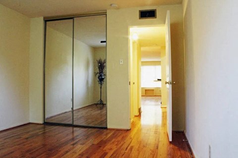 a room with a wooden floor and a large mirror