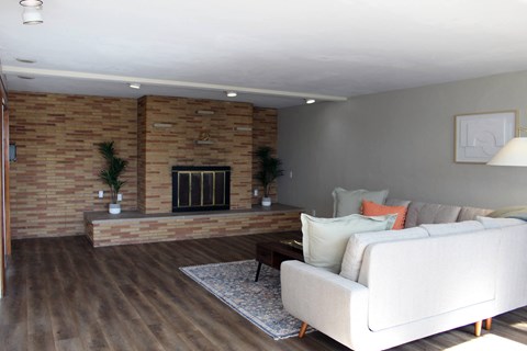 a living room with a white couch and a brick fireplace