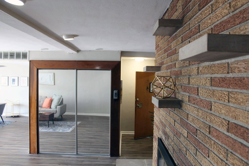 a living room with a brick wall and a glass door