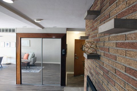 a living room with a brick wall and a glass door