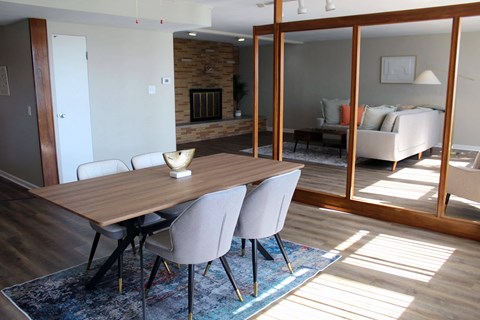 a dining room with a wooden table and white chairs