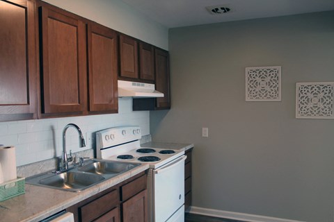 a kitchen with white appliances and wooden cabinets and a sink