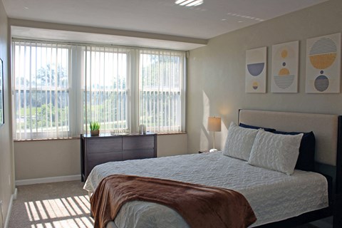 a bedroom with a bed and three windows