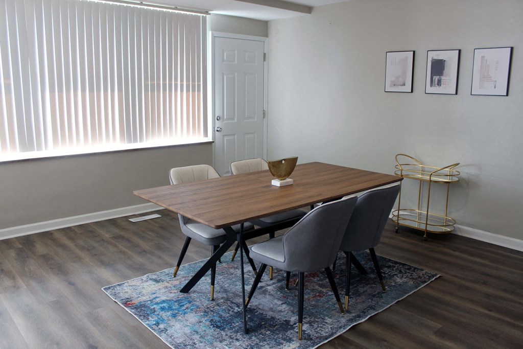 a dining room with a wooden table and white chairs