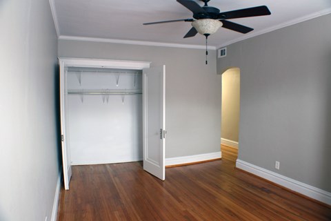 A room with a ceiling fan and a white door.