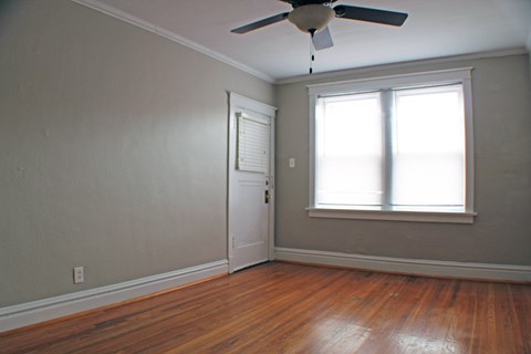 A room with a ceiling fan and a door.