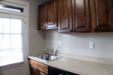 A kitchen with wooden cabinets and a sink.
