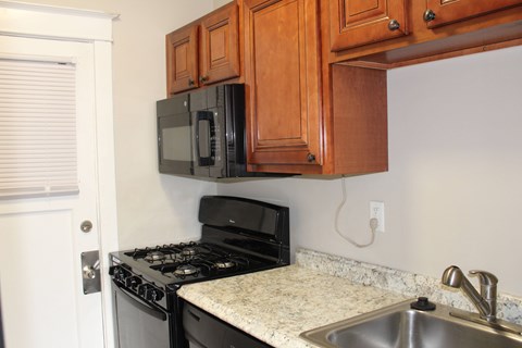 A kitchen with a black stove and microwave.