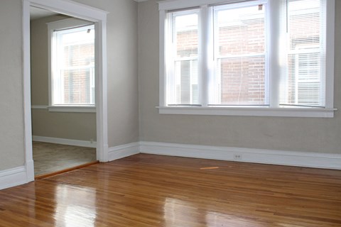 A room with wooden floors and two windows.
